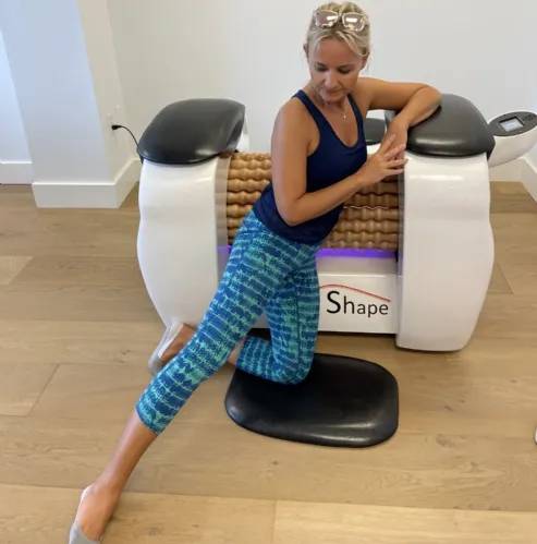 User stretching while using the Roll Magic Body Roll Machine for a massage.