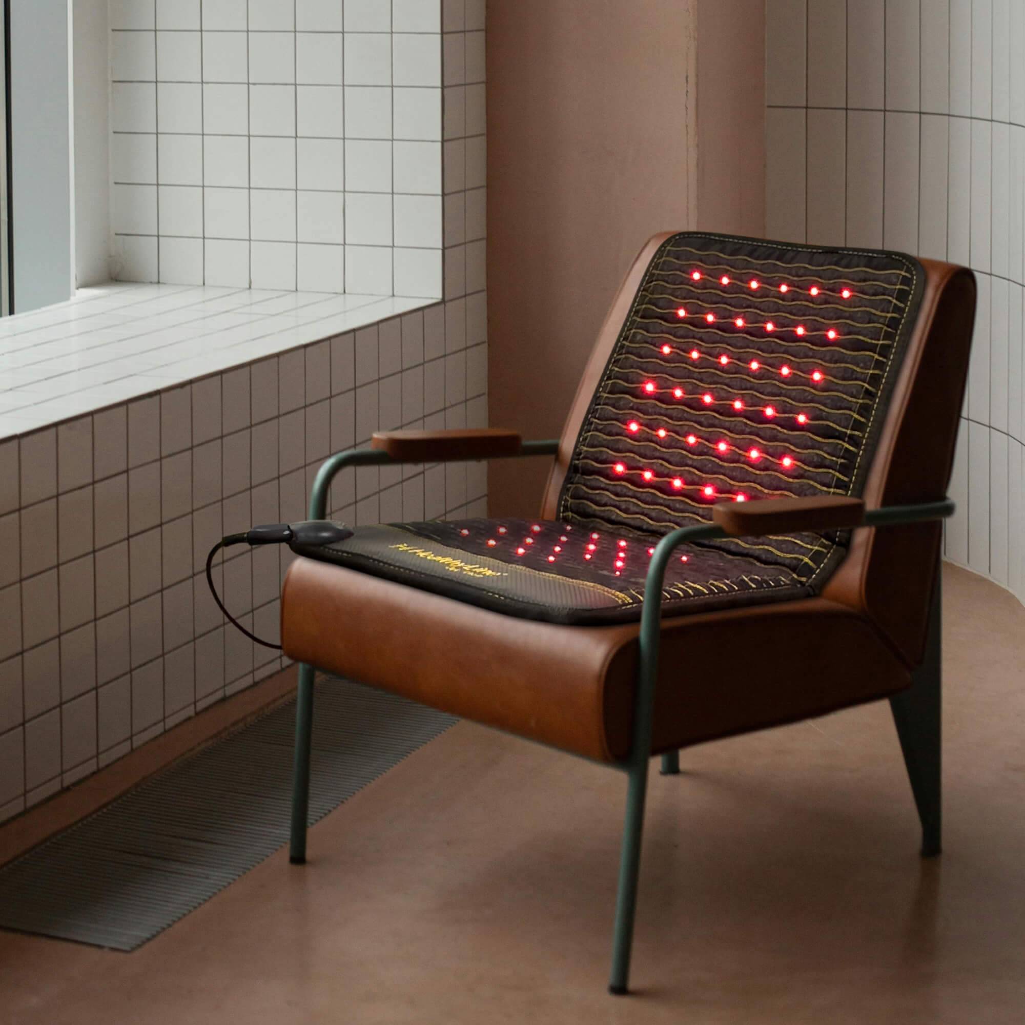 Jet Chair Inframat Pro placed on a brown chair with glowing red lights