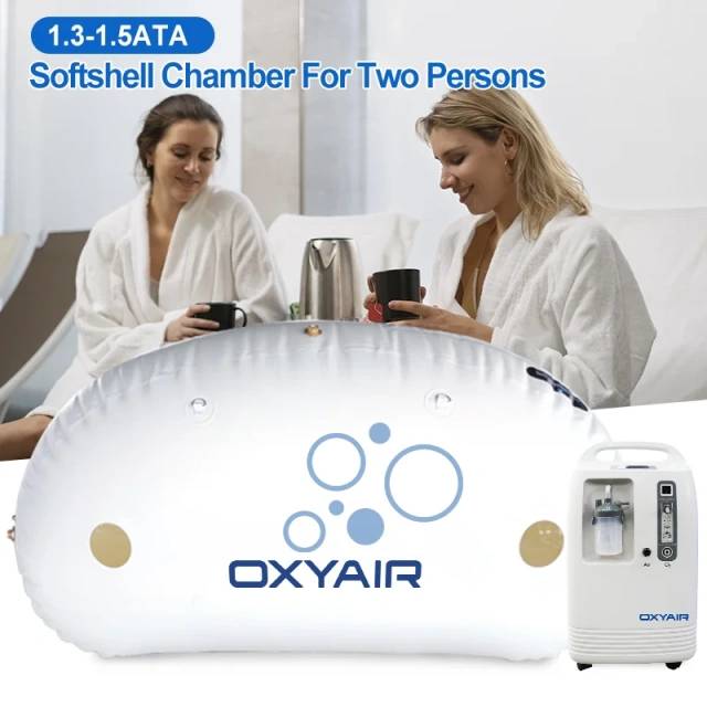 Two women in robes with Oxyair 1.5 ATA chamber and oxygen machine