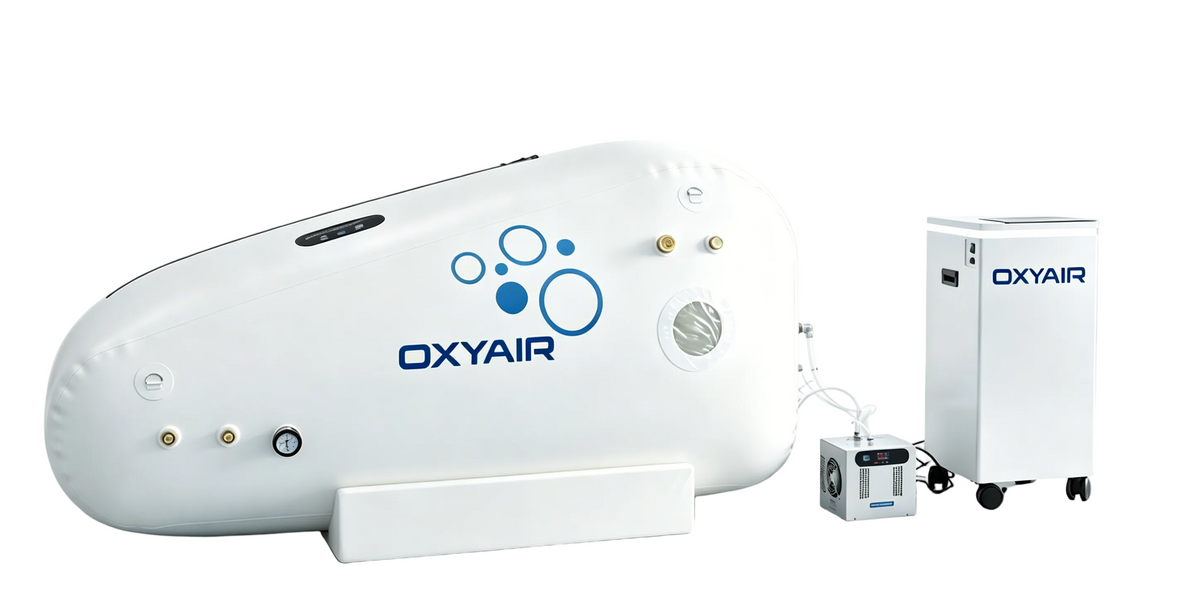 OXYAIR hyperbaric oxygen therapy chamber system with a large white curved chamber on a support base and a separate white oxygen generator unit on wheels, photographed on a clean light gray studio background.
