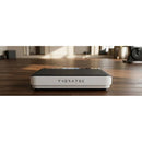 Front view of white THERATEC vibration plate positioned on a wood floor for home wellness and exercise use