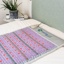 HealthyLine Platinum PEMF mat laid across a bed with red photon lights and a gray control pad