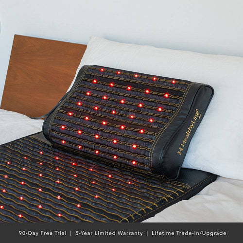 The Jet Pillow on a bed with red photon lights, designed for neck and shoulder support