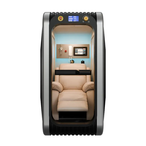 Interior of a hyperbaric oxygen chamber showing a plush cream-colored leather recliner, a touchscreen control interface, and an emergency communication handset.