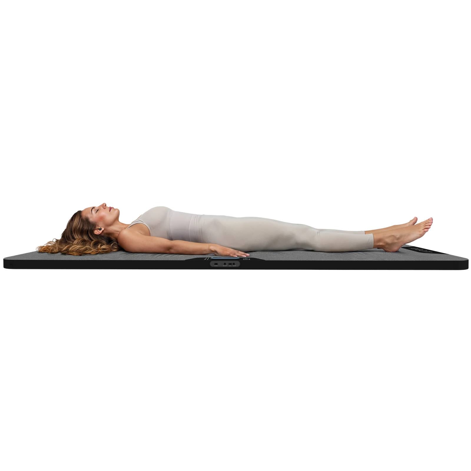 Person relaxing on the Woojer Sound Therapy Bed Mat during an immersive vibroacoustic wellness session